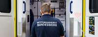 Ein Mann mit „Rettungsdienst Bundeswehr“-T-Shirt steht vor einem offenen Rettungswagen