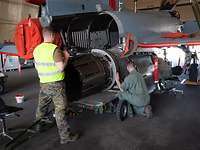 Zwei Bundeswehr-Techniker reparieren in einer Halle das Triebwerk eines Düsenjets