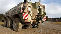 A soldier takes a soil sample from inside a reconnaissance vehicle.