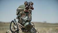 Portrait of a soldier wearing a protective mask and other equipment. Only his eyes are visible.