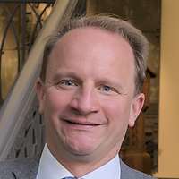 Ein Mensch steht auf einer Treppe und lehnt sich gegen das Geländer.