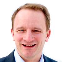 Ein Mensch steht auf einer Treppe und lehnt sich gegen das Geländer.