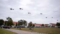 Hubschrauber überfliegen die auf dem Appellplatz angetretenen Soldaten.