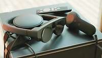 Eine Brille liegt zusammen mit weiteren Geräten auf einem Tisch