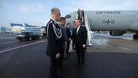 Minister Pistorius is greeted by the German military attaché in front of an air force aircraft.