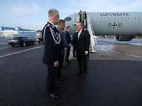  Minister Pistorius is greeted by the German military attaché in front of an air force aircraft.