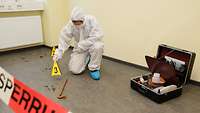 A person in protective gear secures evidence.