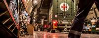 A truck with a red cross stands in the cargo hold of an airplane.