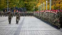 Zwei Kommandeure schreiten die Front vor angetretenen Soldatinnen und Soldaten ab.