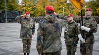 Zwei Männer stehe sich gegenüber und grüßen sich militärisch.