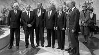Sieben Männer in Anzügen, schwarz-weiß Foto