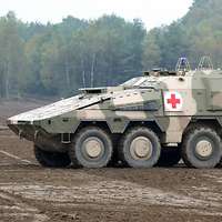 Ein Sanitätskraftfahrzeug vom Typ GTK Boxer A1 steht auf offenem Gelände.