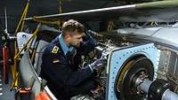 Ein Soldat arbeitet an der Technik eines Hubschraubers