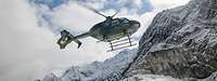 Ein Hubschrauber fliegt im verschneiten Gebirge