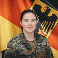 Soldatin vor einer Deutschlandflagge 