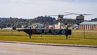 Hinter einem Schild, auf dem Knox Army Heliport steht, landet eine CH-47.