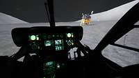 Aus einem dunklen Hubschraubercockpit ist die simulierte Mondlandschaft mit Raumkapsel zu sehen.