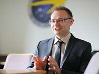 Ein Mann mit Brille erzählt etwas mit Begeisterung und gestikuliert dabei.