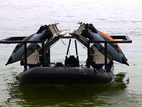 Wasserdrohnen Vier Unterwasserdrohnen hängen an einem Gestell auf einem Schlauchboot