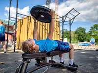 Eine Soldatin liegt auf einer Hantelbank und hebt eine Gewichtsscheibe hoch.