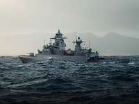 Ein Kriegsschiff fährt auf einem großen Gewässer mit Wellen vor einer bergigen Küste.