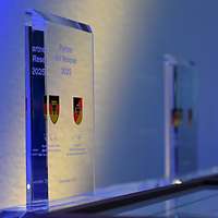 Eine Auszeichnungsplakette aus Glas steht auf einer Präsentationsfläche