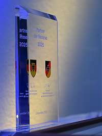 Eine Auszeichnungsplakette aus Glas steht auf einer Präsentationsfläche