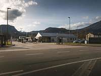 Ein Zaun, dahinter das Wachgebäude und zwei Schranken, im Hintergrund Berge