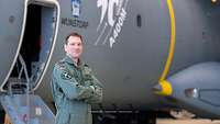 Seitlich vor einem A400M steht Oberst Knoll mit verschränkten Armen.