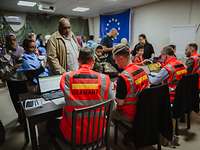 Soldaten in Warnwesten sitzen vor Menschen die Evakuiert werden sollen