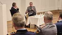 Ein Militärgeistlicher und ein General sitzen an einem Tisch und diskutieren.