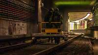 Soldaten schieben einen Wagen über die Gleise im U-Bahn Schacht