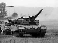 Schwarz-Weiß-Aufnahme: Mehrere Panzer fahren im Gelände.