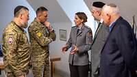 Eine Soldatin spricht mit zwei ukrainischen Soldaten. Einer von beiden trägt eine Kippa.