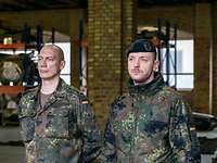Zwei Soldaten in Flecktarn stehen nebeneinander. Der eine trägt eine Feldbluse, der andere eine Kälteschutzjacke.
