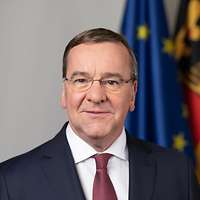 Bundesminister der Verteidigung Boris Pistorius schaut lächelnd für eine Portraitaufnahme in die Kamera.