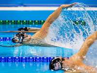 Drei Schwimmer beim Rückenschwimmen auf ihren Bahnen