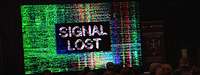 Ein großer Bildschirm mit bunten Linien zeigt den Zuschauenden die verzerrte Aufschrift Signal#en lost#en.
