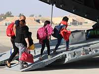 People board a military aircraft during an evacuation