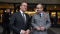 Boris Pistorius und der Generalinspekteur stehen lächelnd nebeneinander.