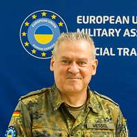 Ein Soldat steht vor einem blauen Hintergrund