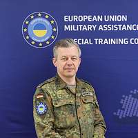 Ein Soldat steht vor einem blauen Hintergrund