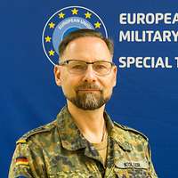 Ein Soldat steht vor einem blauen Hintergrund