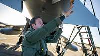 Ein Kampfpilot überprüft ein Kampfflugzeug vom Typ Eurofighter.