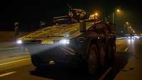 Ein Panzer der Bundeswehr fährt auf einer Autobahn in der Nacht.