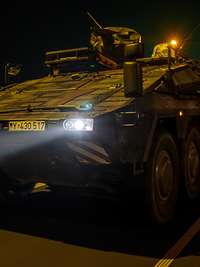 Ein Panzer der Bundeswehr fährt auf einer Autobahn in der Nacht.