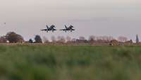 Two Eurofighter jets side by side approaching the runway.