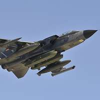 Ein Kampfflugzeug vom Typ Tornado mit verschiedenen Flugkörpern im Flug von unten gesehen