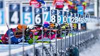 Mehrere Biathlon-Sportler liegen am Schiessstand nebeneinander.