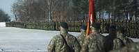 Soldatinnen und Soldaten sind auf einem schneebedeckten Platz in Formationen angetreten.